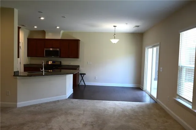 a kitchen with kitchen island granite countertop stainless steel appliances a sink a refrigerator and a counter top space