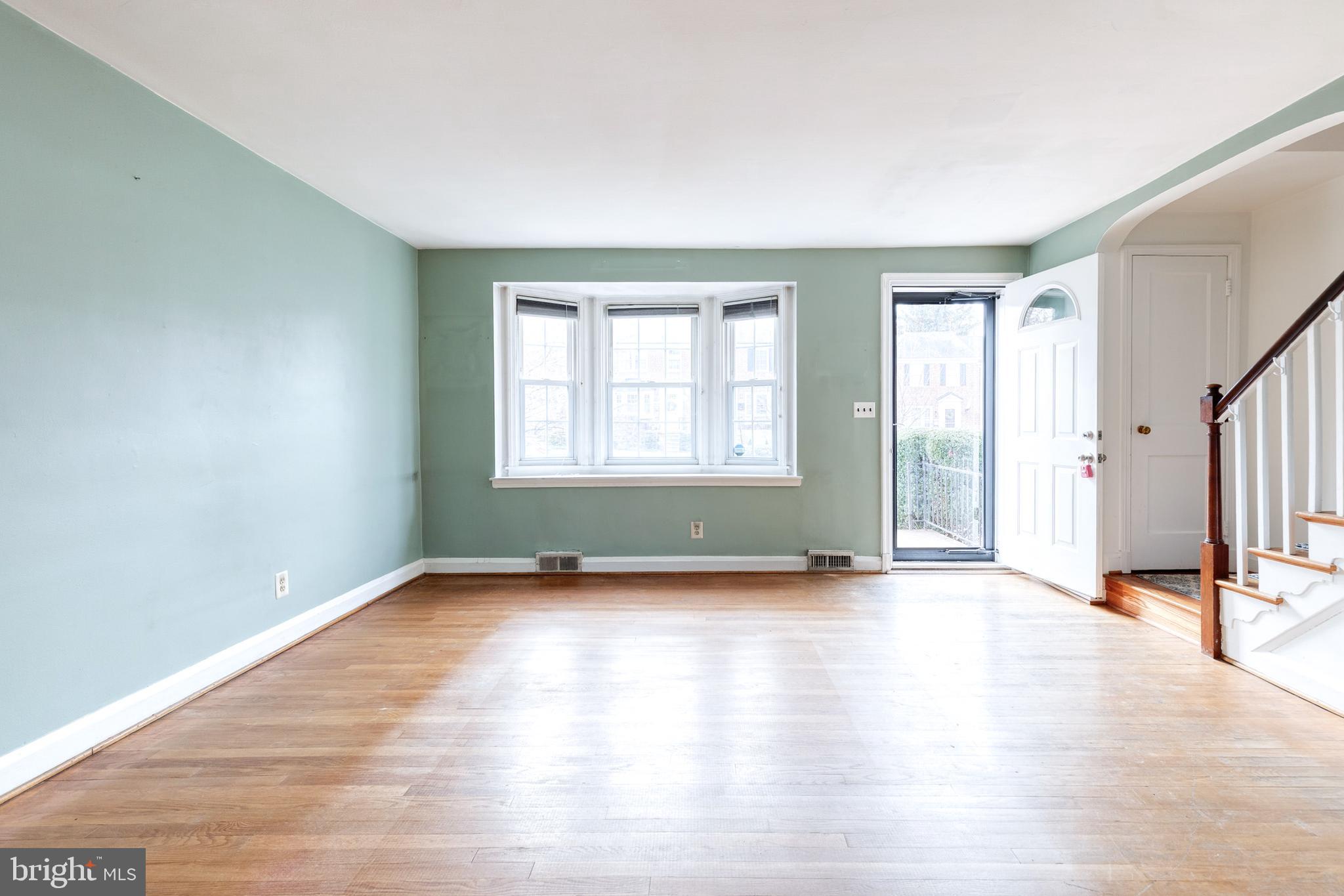 122 Regester Avenue Baltimore, MD 21212 - Photo 8 of 36 an empty room with wooden floor and windows