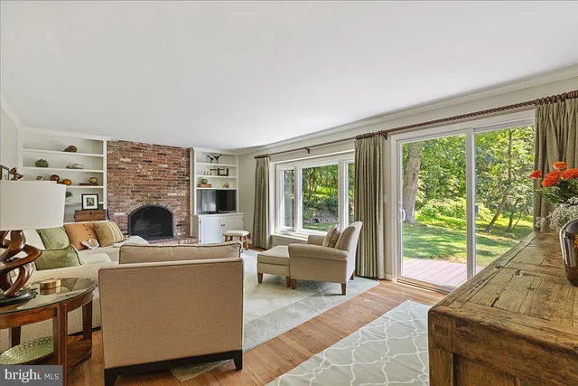 a living room with furniture a fireplace and a floor to ceiling window