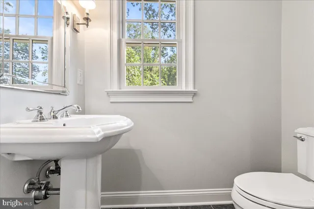 a bathroom with a sink a toilet and a window