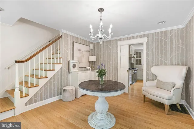 a dining room with furniture a chandelier and wooden floor
