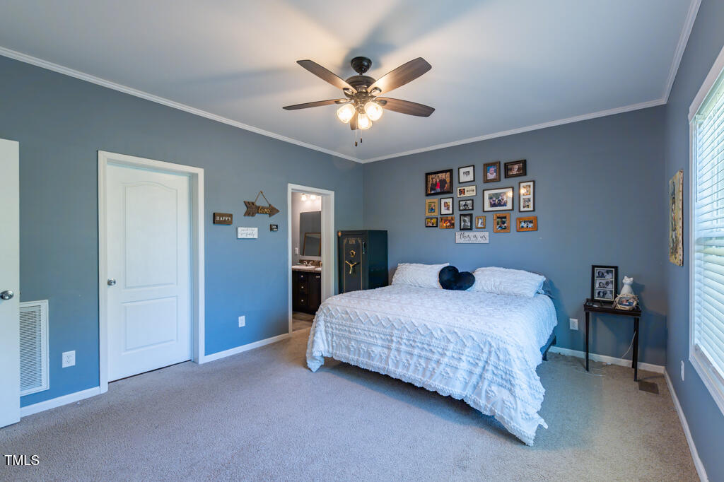 5912 Mt Zion Road Snow Camp, NC 27349 - Photo 20 of 33 a bedroom with a bed and a chandelier