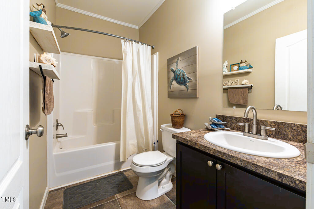 5912 Mt Zion Road Snow Camp, NC 27349 - Photo 26 of 33 a bathroom with a granite countertop sink toilet a mirror a bathtub and shower