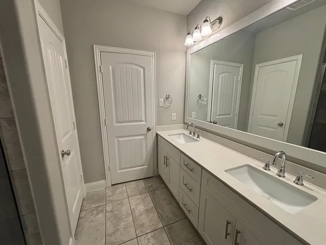 an empty room with a chandelier fan and windows