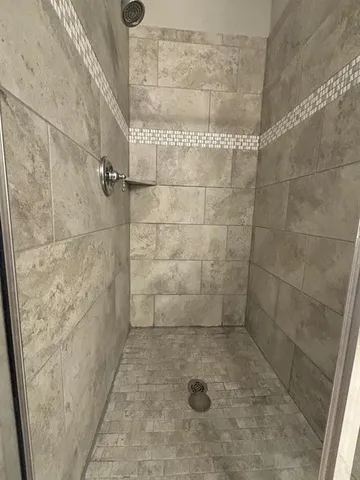 a spacious bathroom with a double vanity sink a mirror and a