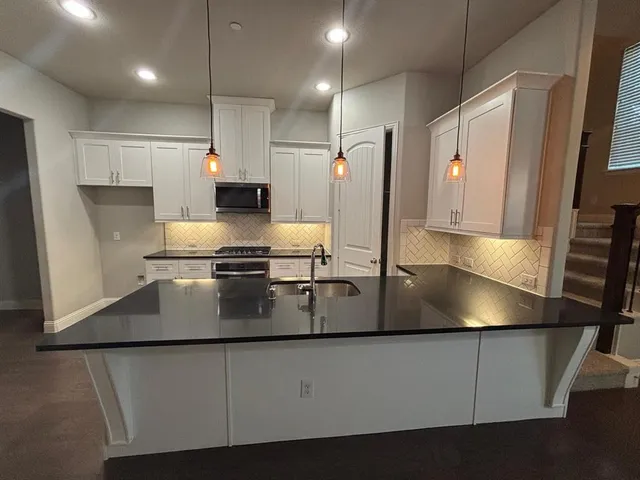 a view of a kitchen with a sink and a large window