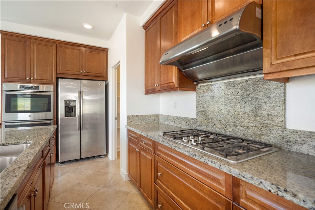 13296 Joliet Drive Rancho Cucamonga, CA 91739 - Photo 13 of 69 a kitchen with granite countertop a stove and a refrigerator