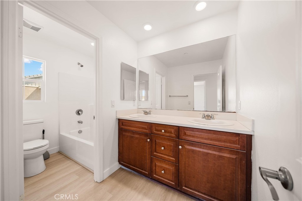 13296 Joliet Drive Rancho Cucamonga, CA 91739 - Photo 31 of 69 a spacious bathroom with a granite countertop double vanity sink a mirror and a toilet