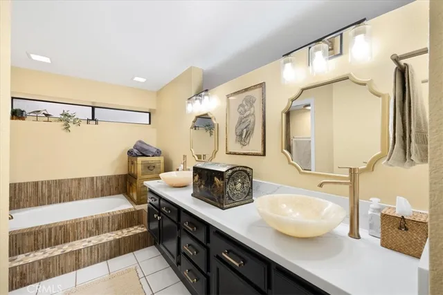 a bathroom with a tub sink and mirror