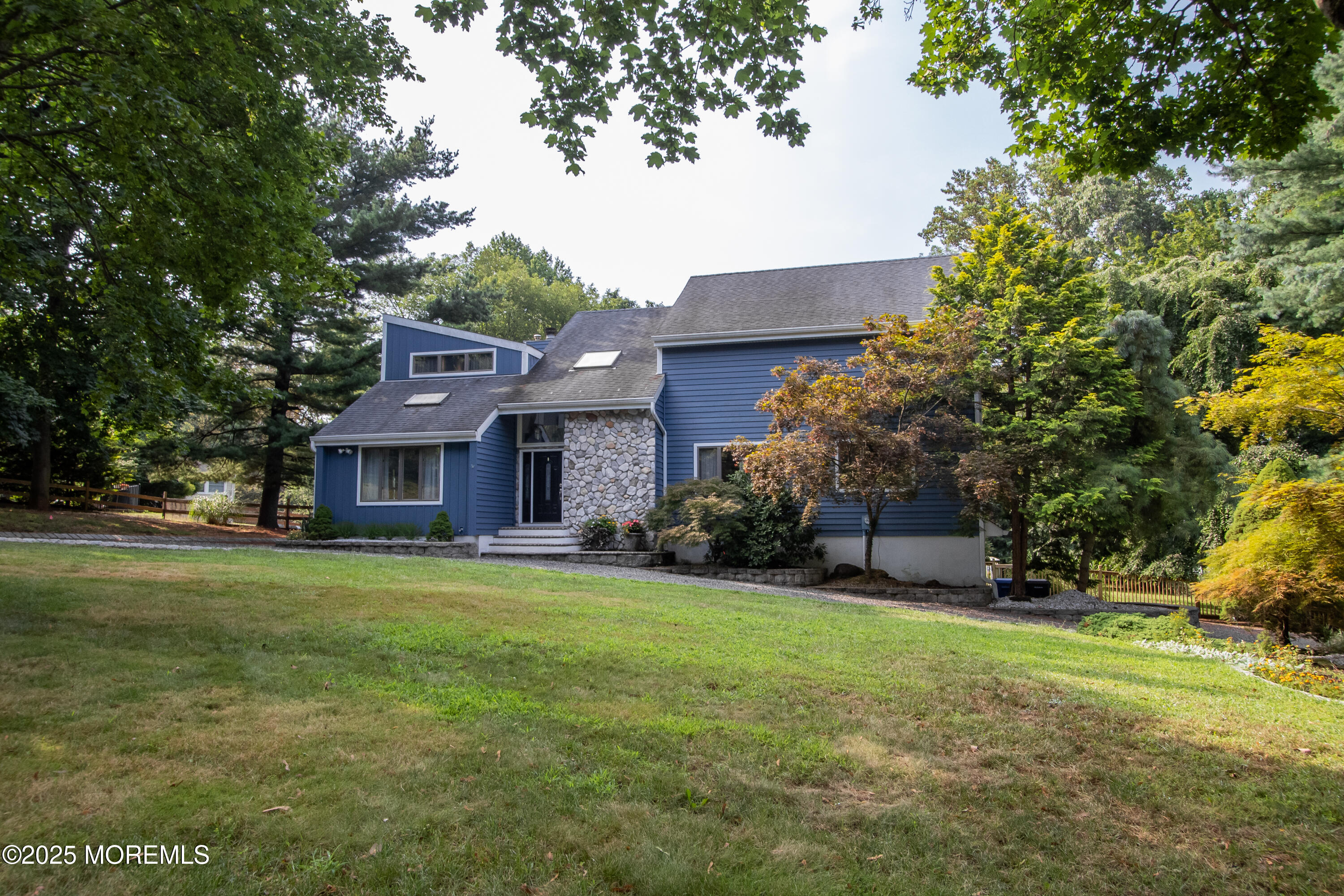 a view of a big house with a big yard and large trees
