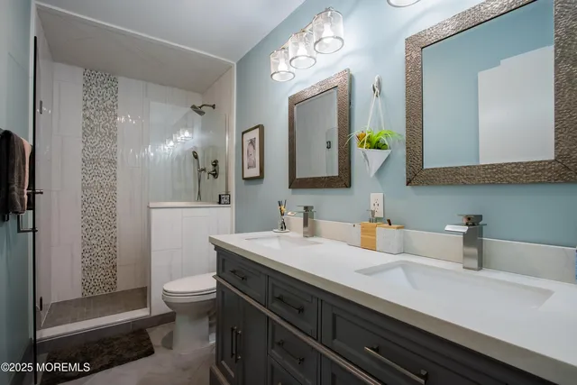 a bathroom with a double vanity sink mirror and toilet