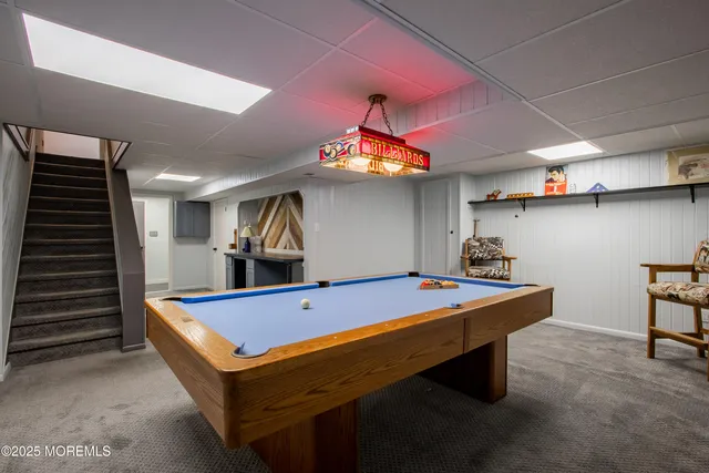 a room with pool table and windows