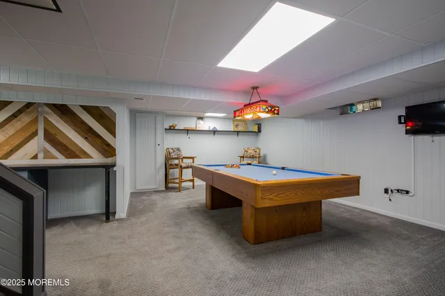 a room with pool table and windows