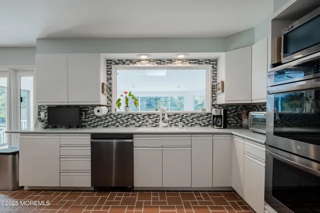 a kitchen with granite countertop white cabinets and white appliances