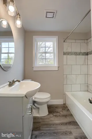 a bathroom with a sink toilet vanity and bathtub
