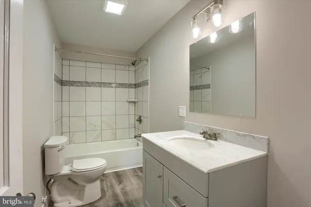 a bathroom with a sink toilet vanity and shower