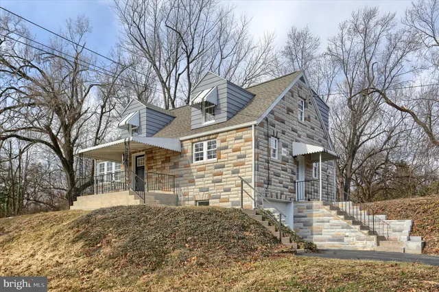 a front view of a house with a yard covered in snow