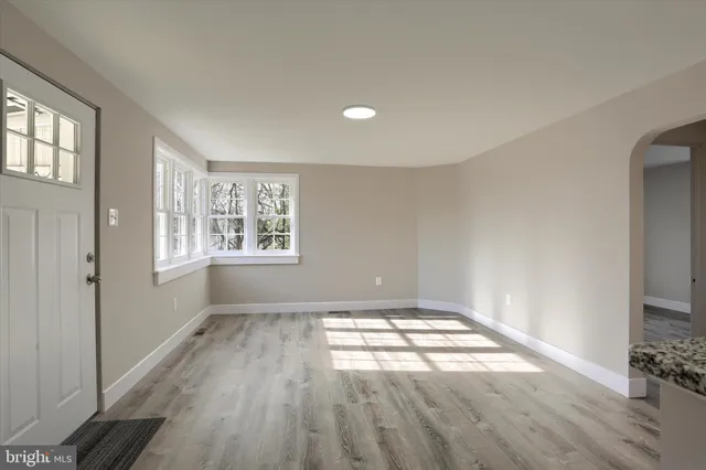 wooden floor in an empty room with a window