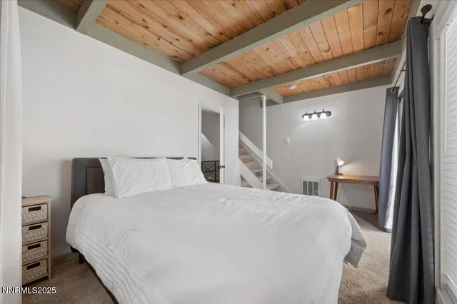 a large bed sitting in a bedroom next to a lamp