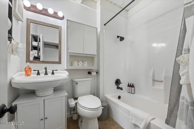 a bathroom with a bathtub sink mirror and toilet
