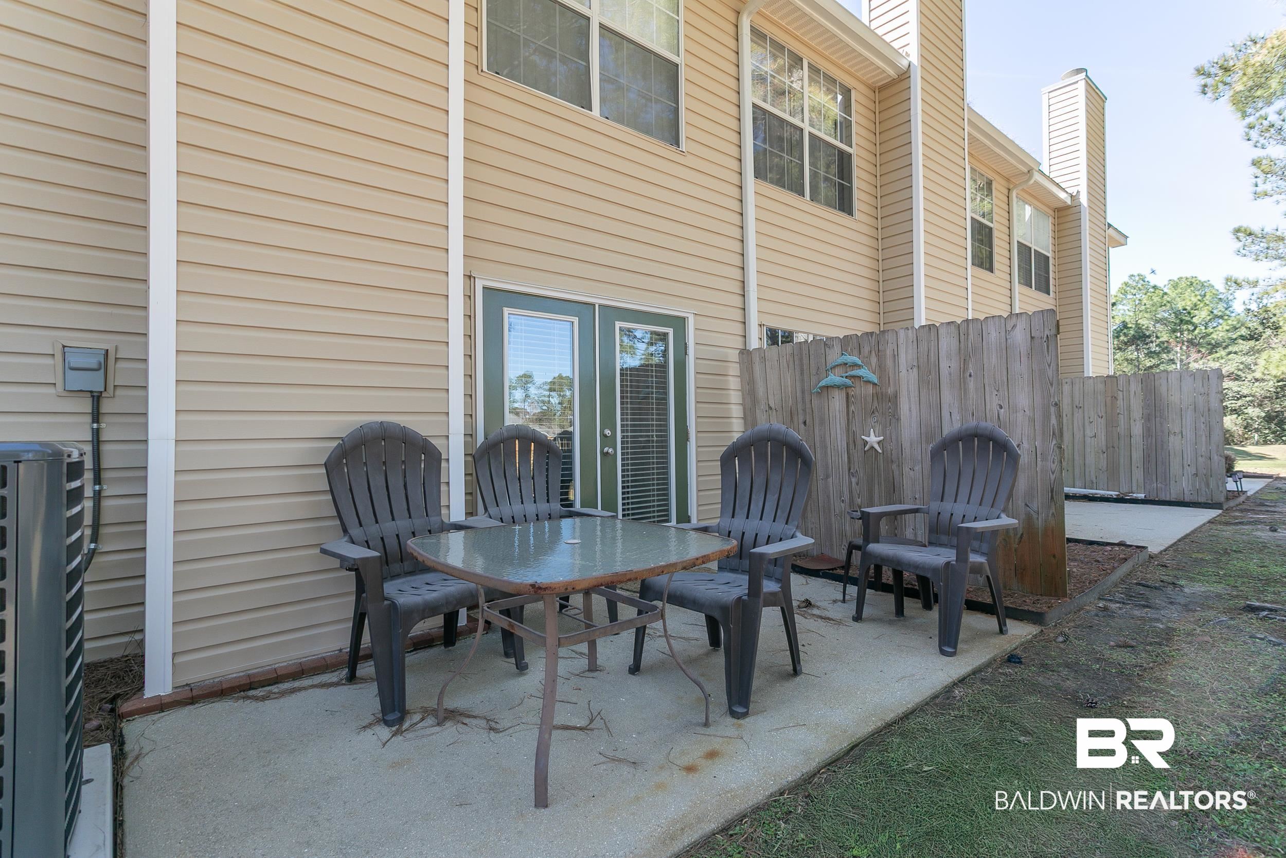 1517 Regency Road, Unit 33 Gulf Shores, AL 36542 - Photo 27 of 29 View of patio / terrace featuring outdoor dining space and fence