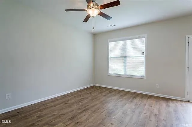 a view of an empty room and a ceiling fan