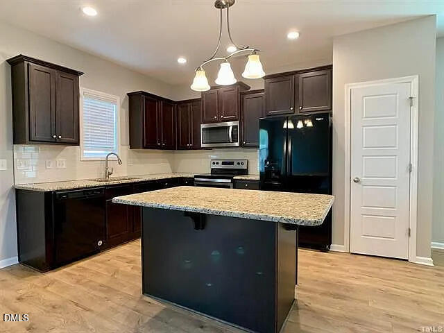134 West Lumber Court Clayton, NC 27520 - Photo 3 of 23 a kitchen with a stove a sink a refrigerator and cabinets