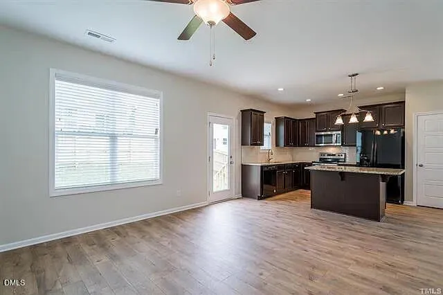 a large kitchen with stainless steel appliances granite countertop a large center island and a wooden floor