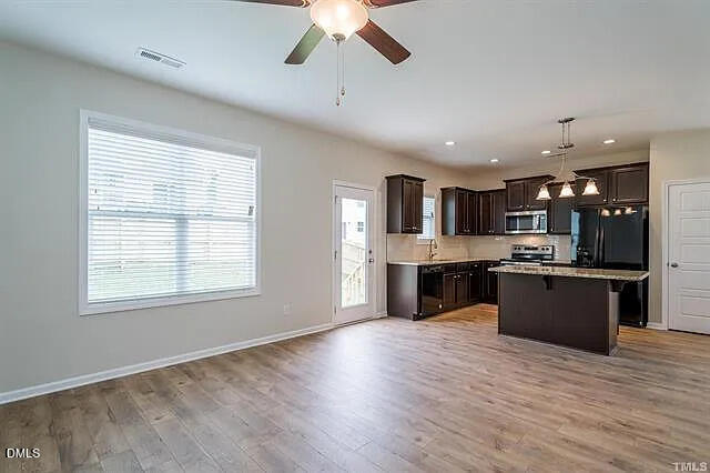 134 West Lumber Court Clayton, NC 27520 - Photo 7 of 23 a large kitchen with stainless steel appliances granite countertop a large center island and a wooden floor