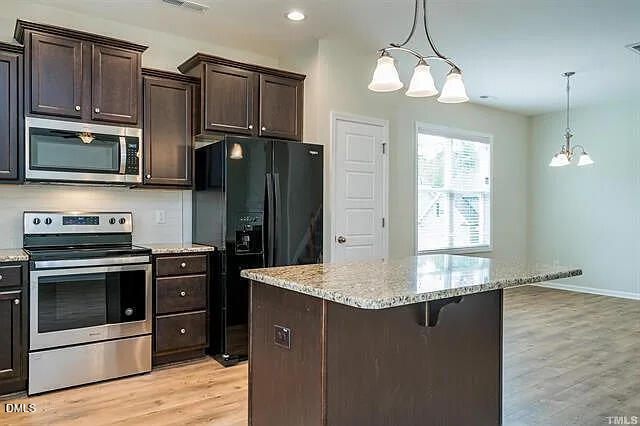 134 West Lumber Court Clayton, NC 27520 - Photo 8 of 23 a kitchen with stainless steel appliances granite countertop a refrigerator a stove a sink and a microwave