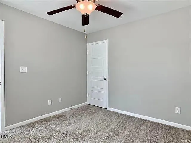 an empty room with a ceiling fan and a window