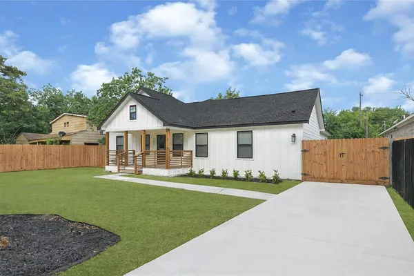 a front view of a house with a garden and yard