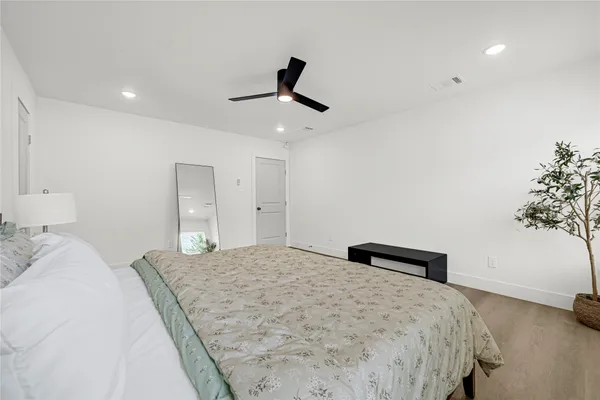 a bedroom with a bed and a potted plant