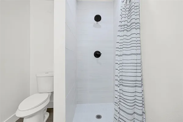a bathroom with a toilet and a shower