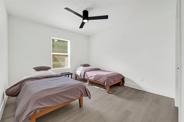 a bedroom with two beds and a ceiling fan