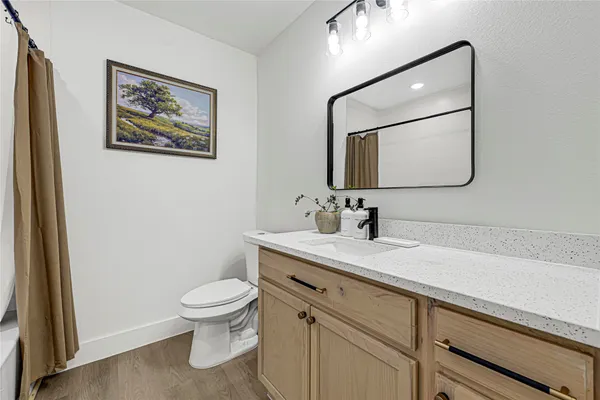 a bathroom with a toilet a sink and mirror