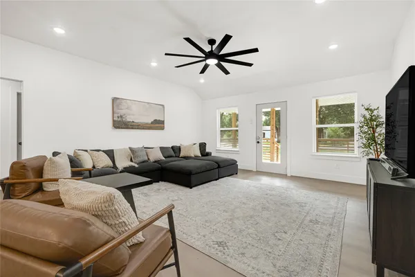 a living room with furniture a flat screen tv and a large window
