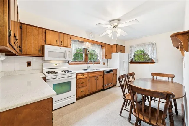 a kitchen with stainless steel appliances granite countertop a white cabinets and a stove top oven