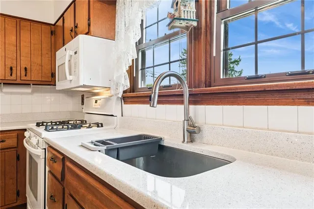 a kitchen with a sink a stove and a microwave
