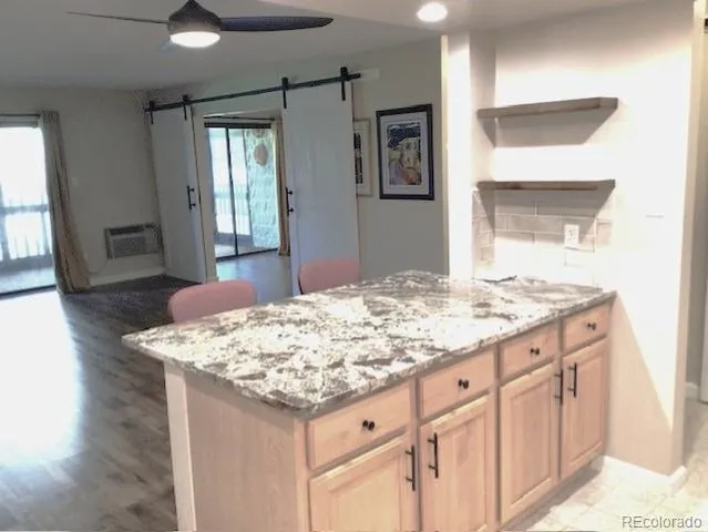a room with kitchen island a sink dishwasher and fireplace with wooden floor