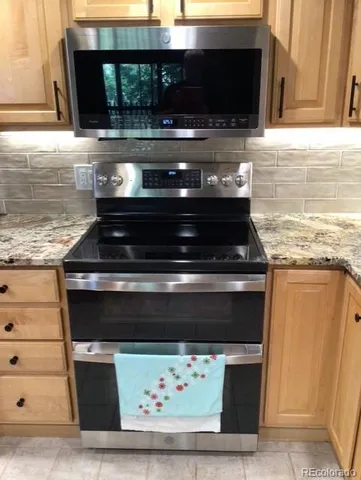 a stove top oven sitting inside of a kitchen