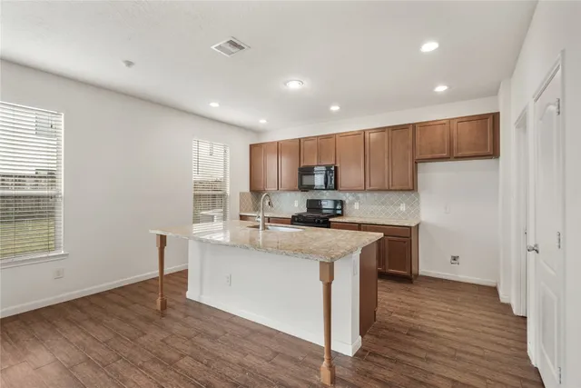 a kitchen with a sink a microwave a refrigerator and cabinets