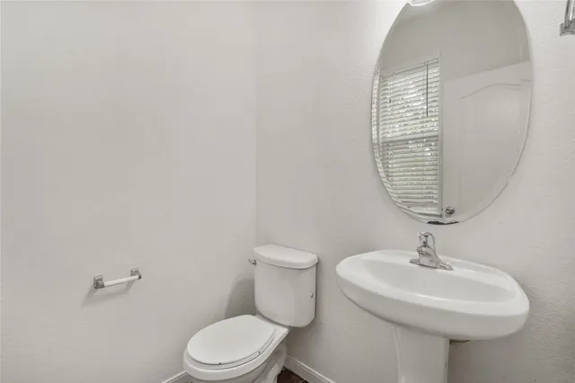 a bathroom with a sink a toilet and a mirror