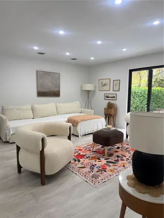 a view of an empty room with wooden floor and a large window