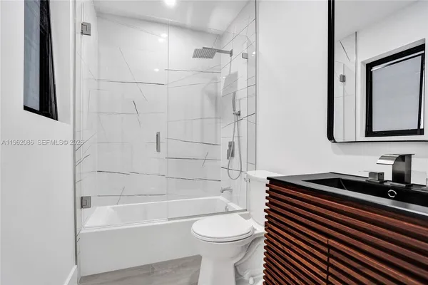a view of an empty room with wooden floor and window