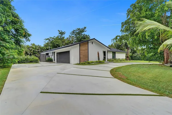 an aerial view of a house with a yard and lake view