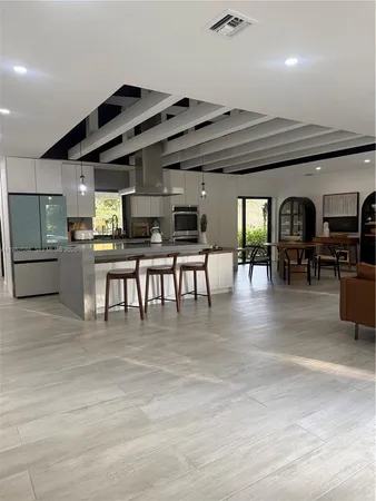 a large kitchen with stainless steel appliances granite countertop a large counter top and a wooden floors