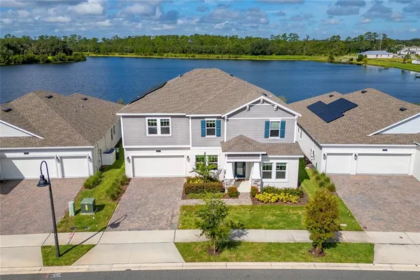 an aerial view of a house with a garden and lake view