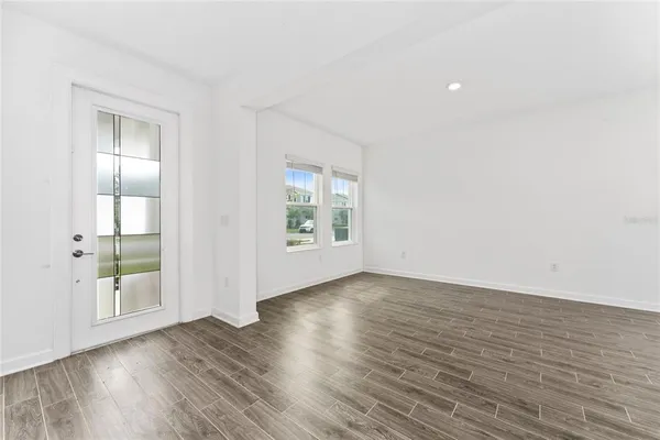 a large kitchen with cabinets wooden floor and stainless steel appliances
