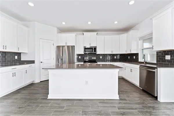 a kitchen with stainless steel appliances granite countertop a refrigerator and a sink